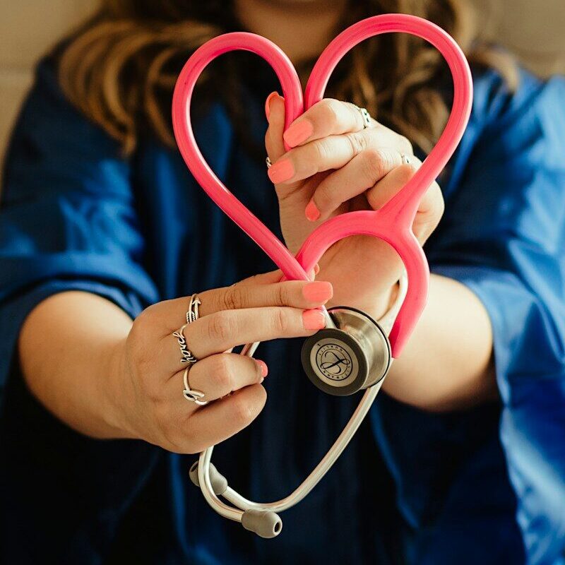 girl in blue jacket holding red and silver ring